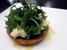 Caramelos de gambas con hojas de rúcula, queso parmesano y aceite