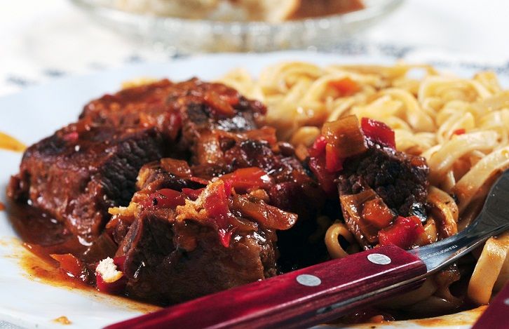 Estofado de ternera con guarnición de pasta.